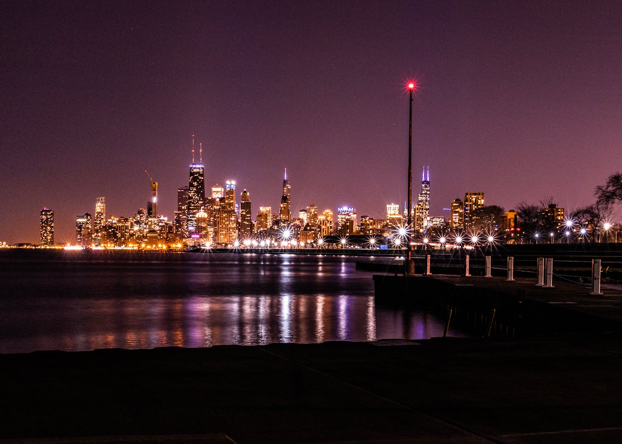 Vibrant Chicago skyline illuminated at night with reflections on Lake Michigan.