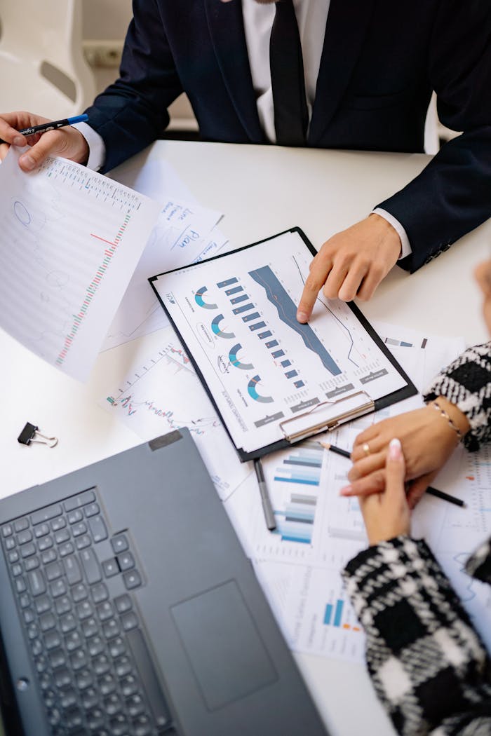who-we-are Teamwork in a modern office setting with charts and laptops showcasing collaboration.